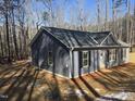 Newly constructed home featuring light blue siding and a grey roof in a wooded setting at 810 Jasmine Rd, Fuquay Varina, NC 27526