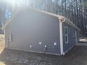 Side view of a newly constructed house featuring light blue siding and white trim at 810 Jasmine Rd, Fuquay Varina, NC 27526