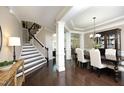Open-concept dining room featuring hardwood floors, elegant chandelier, and staircase at 106 Rolling Meadows Ln, Chapel Hill, NC 27517