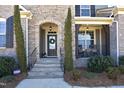 Charming covered front porch with stone archway, rocking chairs, and manicured landscaping at 106 Rolling Meadows Ln, Chapel Hill, NC 27517