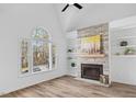 Bright living room with stone fireplace, hardwood floors, and large window offering scenic views at 107 Kingsmill Rd, Cary, NC 27511