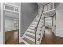 Elegant staircase with wood handrail, white risers, and views into other rooms at 126 Claire Dr, Clayton, NC 27520