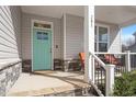 Inviting front porch with a turquoise door, stone accents, seating, and stylish architectural details at 201 Northview Dr, Middlesex, NC 27557