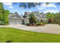 Spacious home boasts a three-car garage and a circular driveway surrounded by lush greenery at 219 Colvard Park Dr, Durham, NC 27713