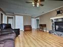 Spacious living room featuring wood floors, a stone fireplace, and a comfortable seating area at 22 Woodridge Ln, Cameron, NC 28326