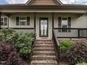 Inviting front porch with brick steps and a black-railed porch that leads to a glass-paned front door at 30 Imperial Dr, Clayton, NC 27527