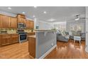 Open kitchen features stainless steel appliances, granite countertops and wood cabinets at 3003 Weston Green Loop, Cary, NC 27513