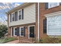 Townhouse exterior showcases brick and siding, accented by black shutters and tidy landscaping at 318 Mccauley St # 2, Chapel Hill, NC 27516