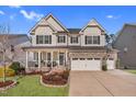 Charming two-story home featuring a stone facade, inviting front porch, and well-manicured lawn at 3460 Willow Green Dr, Apex, NC 27502