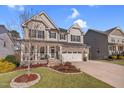 Charming two-story home featuring a stone facade, inviting front porch, and well-manicured lawn at 3460 Willow Green Dr, Apex, NC 27502