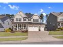 Charming two-story home featuring a stone facade, inviting front porch, and well-manicured lawn at 3460 Willow Green Dr, Apex, NC 27502