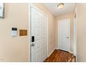 Foyer with a white door, security system, and a wood-look floor at 5816 Pointer Dr # 102, Raleigh, NC 27609
