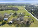 An aerial view of a farmhouse estate with multiple outbuildings near a country road at 7055 Old 421 Rd, Liberty, NC 27298