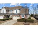 Charming townhome with a brick-accented garage, beige siding, and well-manicured landscaping at 8311 Yaxley Hall Dr, Raleigh, NC 27616