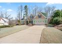 Inviting two-story home with a long driveway leading to an attached two-car garage and lush front lawn at 86 Pappy Ln, Garner, NC 27529