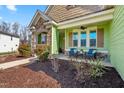 Relaxing front porch with comfortable seating, complemented by neat landscaping and charming architectural details at 86 Pappy Ln, Garner, NC 27529