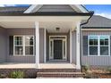 Inviting covered front porch with brick steps, white pillars, and stylish lighting. The house number is visible on the siding at 9315 Turkey Way, Middlesex, NC 27557