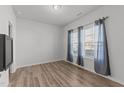 Bright bedroom with wood-look flooring, large windows with gray curtains, and ample natural light at 95 Westbrook Ln, Franklinton, NC 27525