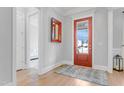 Inviting entryway with hardwood floors, red door and sidelight provides an abundance of light at 1129 Sequoia Creek Ln, Cary, NC 27519