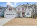Charming two-story home with a well-manicured lawn, two-car garage, and inviting front porch at 1129 Sequoia Creek Ln, Cary, NC 27519