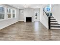 Bright living room featuring a fireplace, large windows and an adjacent staircase at 120 Breyla Way, Holly Springs, NC 27540