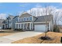 Charming two-story home with a welcoming front porch and a well-manicured lawn, complete with an attached two-car garage at 143 Rossell Park Cir, Garner, NC 27529