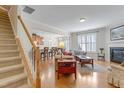 Bright living room features hardwood floors, a fireplace, and staircase access to the upper level at 146 Skyros Loop, Cary, NC 27519