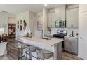 Modern kitchen with white countertops, stainless steel appliances, and a breakfast bar with seating at 1745 Pie Filling Dr, Haw River, NC 27258