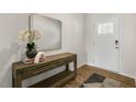 Inviting entryway featuring wood floors, console table with decor, mirror, and front door with glass panel at 186 Ethel Ln, Angier, NC 27501