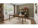 Inviting office space with a wooden desk, shelving unit, area rug, and large window at 186 Ethel Ln, Angier, NC 27501