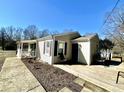 Tan house with brown shutters, covered porch and a wooden deck with wire railing at 2001 S Ashland Dr, Burlington, NC 27217