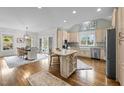 Bright open kitchen featuring an island, stainless steel appliances, and adjacent dining area at 220 Epps Clark Rd, Siler City, NC 27344