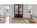 Warm and bright foyer with wood floors and a view of the home's front exterior through glass paneled double doors at 2623 Marchmont St, Raleigh, NC 27608