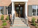 Inviting front entrance with a stylish dark double door, stone steps and elegant columns at 2623 Marchmont St, Raleigh, NC 27608