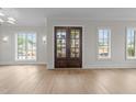 Bright living room featuring hardwood floors, double doors, and abundant natural light at 2623 Marchmont St, Raleigh, NC 27608