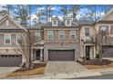 Beautiful exterior of a townhome with a two-car garage, stone accents, and landscaped front yard at 410 Bent Tree Ln, Cary, NC 27519
