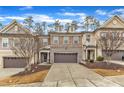 Townhome exterior with a two-car garage, brick accents, and a cozy front yard at 410 Bent Tree Ln, Cary, NC 27519
