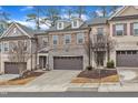 A row of townhomes showcases an attractive exterior with brick, stone accents, and private garages at 410 Bent Tree Ln, Cary, NC 27519