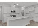 A modern white kitchen featuring an island, stainless steel appliances, and pendant lighting at 44 Fairwinds Drive Dr, Lillington, NC 27546