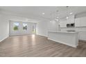 Open-concept kitchen with island, flowing into a bright living area with large windows at 44 Fairwinds Drive Dr, Lillington, NC 27546