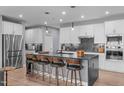 An open-concept kitchen boasts an island with barstool seating, stainless steel appliances, and sleek marble countertops at 50 Sneed Ln, Fuquay Varina, NC 27526