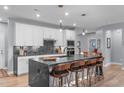An open-concept kitchen boasts an island with barstool seating, stainless steel appliances, and sleek marble countertops at 50 Sneed Ln, Fuquay Varina, NC 27526