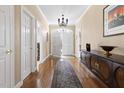 Inviting foyer with hardwood floors, a decorative chandelier, and a view of the arched front door at 50002 Brogden, Chapel Hill, NC 27517