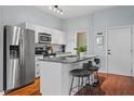 Well-equipped kitchen with a stainless steel refrigerator, an island with seating, and modern finishes at 506 N Mangum St # 303, Durham, NC 27701