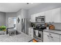 Stylish kitchen featuring stainless steel appliances, white cabinetry, and trendy backsplash at 506 N Mangum St # 303, Durham, NC 27701