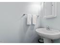 Clean half bathroom with a pedestal sink and white towels providing a minimalist design at 510 Berry Chase Way, Cary, NC 27519