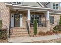 Inviting front porch featuring a classic brick facade, rocking chairs, and seasonal floral wreath on door at 6236 Annabella Rd, Rocky Mount, NC 27803