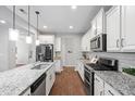 Bright kitchen boasts granite countertops, white cabinets, and stainless steel appliances at 624 Metro Station, Apex, NC 27502