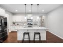 Modern kitchen with a large island, granite countertops, stainless appliances, and ample storage space at 624 Metro Station, Apex, NC 27502