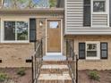 Inviting home entrance featuring a wood door, brick steps, black railings and shutters at 1041 Limerick Ln, Durham, NC 27713